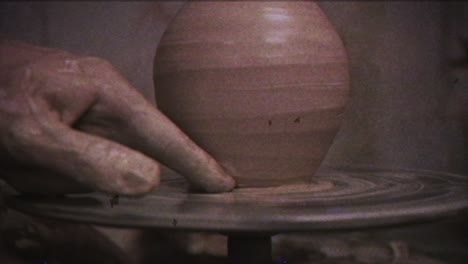 the potter makes a jug of clay. vintage effect. a man makes a vase on a potter's wheel