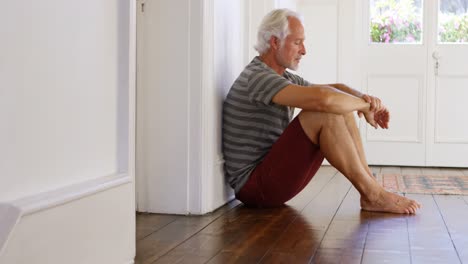 senior man sitting on floor at home 4k