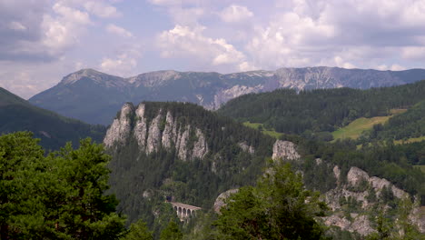 stunning landscape time lapse with mountains, greenery and fast moving clouds - panning shot