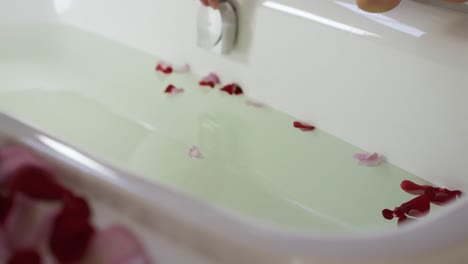 Low-section-of-caucasian-woman-getting-into-tub-in-hotel