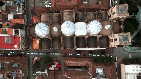 Drone-Aéreo-Sobre-La-Nueva-Catedral-De-Cuenca,-Ecuador,-Techos-Del-Centro-Histórico-De-La-Ciudad-Y-Tres-Cúpulas-Blancas-De-La-Iglesia,-Arquitectura-Latinoamericana-Colonial-Tradicional