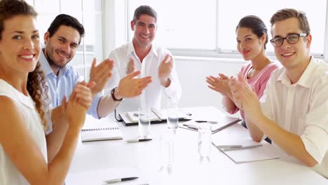 team of business people clapping at the camera