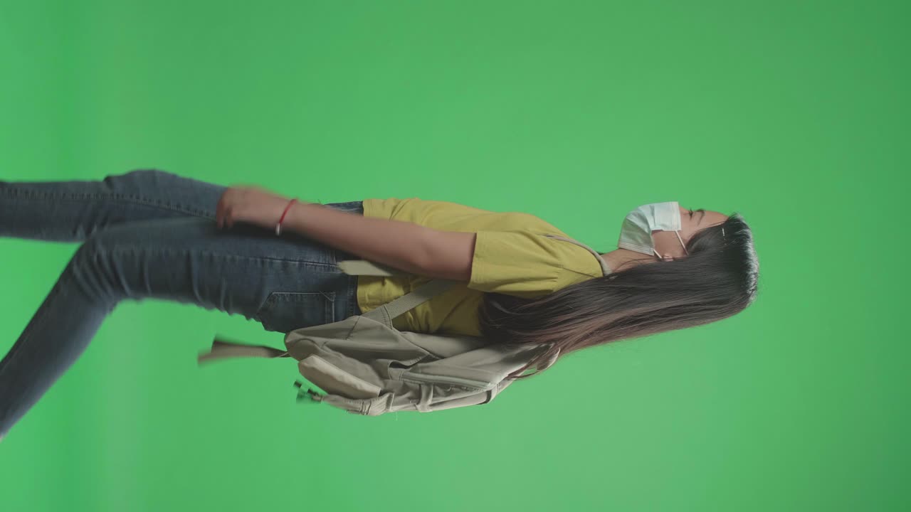 Side View Of Asian Girl Student Wearing Mask And Walking To School On Green Screen Chroma Key
