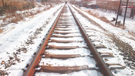 Tiro-Inclinado-De-Las-Vías-Del-Tren-Corriendo-A-Lo-Lejos-De-Una-Pequeña-Ciudad-Industrial-China-En-El-Invierno