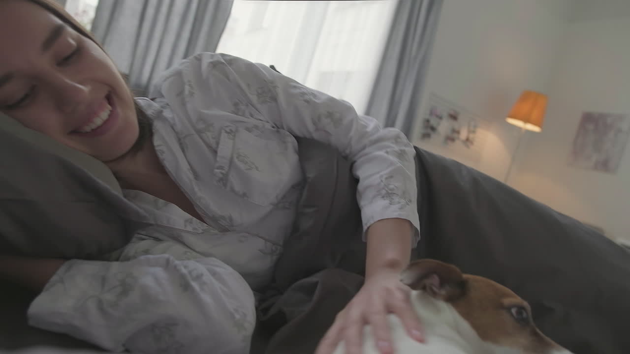 Donna che si sveglia a letto e una coppia che si rilassa con un cane sul divano