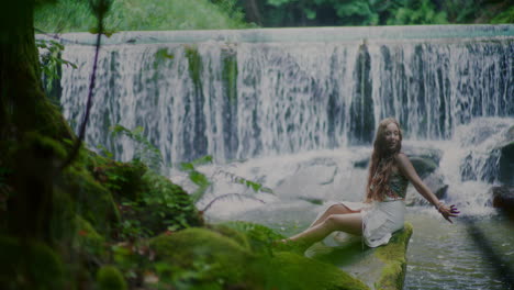 mujer hermosa sacando lo mejor de la vida relajándose y meditando frente a la cascada