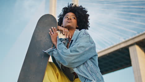 carefree skateboarder relaxing street holding longboard close up.  girl