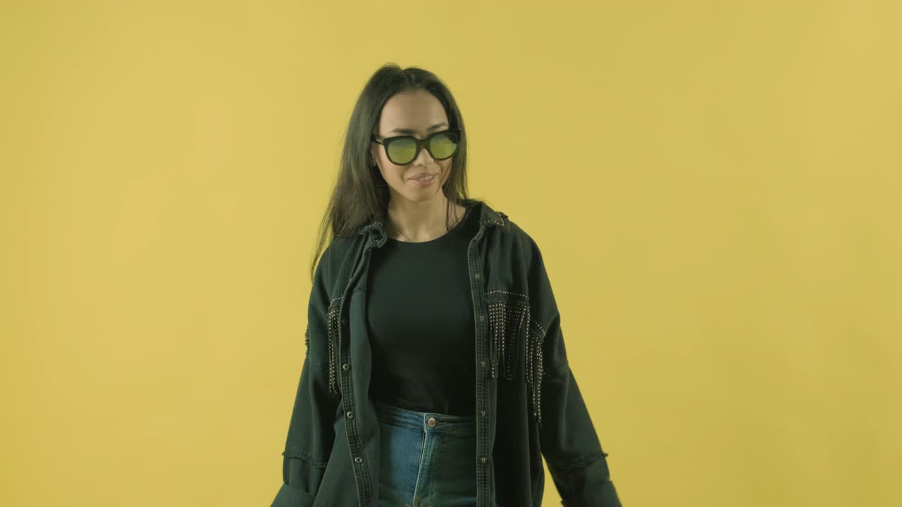 joven hermosa con bolsas de compras en el fondo amarillo