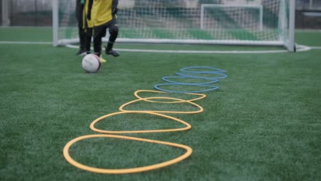 a children's football team trains at the stadium under the guidance of a coach. kids in sports uniforms practice ball exercises, improve technique, and develop teamwork on the green field