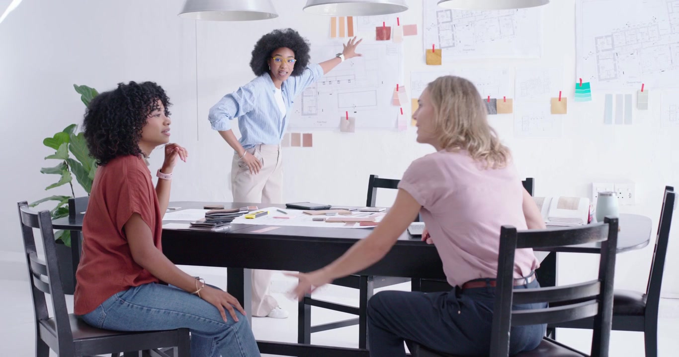 Diverse coworkers watching designer grabbing swatches, arranging wall in white studio for approval