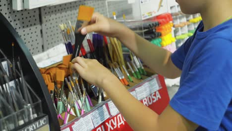 VINNITSA, UKRAINE - AUGUST 20, 2018: Boy in the stationery store choose goods for school and office. Back to school