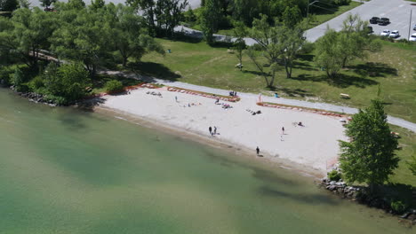 Luftaufnahme-Aus-Dem-Hohen-Winkel-Von-Menschen,-Die-Sich-Am-Strand-Von-Innisfil-An-Der-Küste-Des-Simcoe-Sees-Entspannen