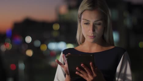 Video-of-thoughtful-caucasian-businesswoman-using-tablet-at-night-in-office