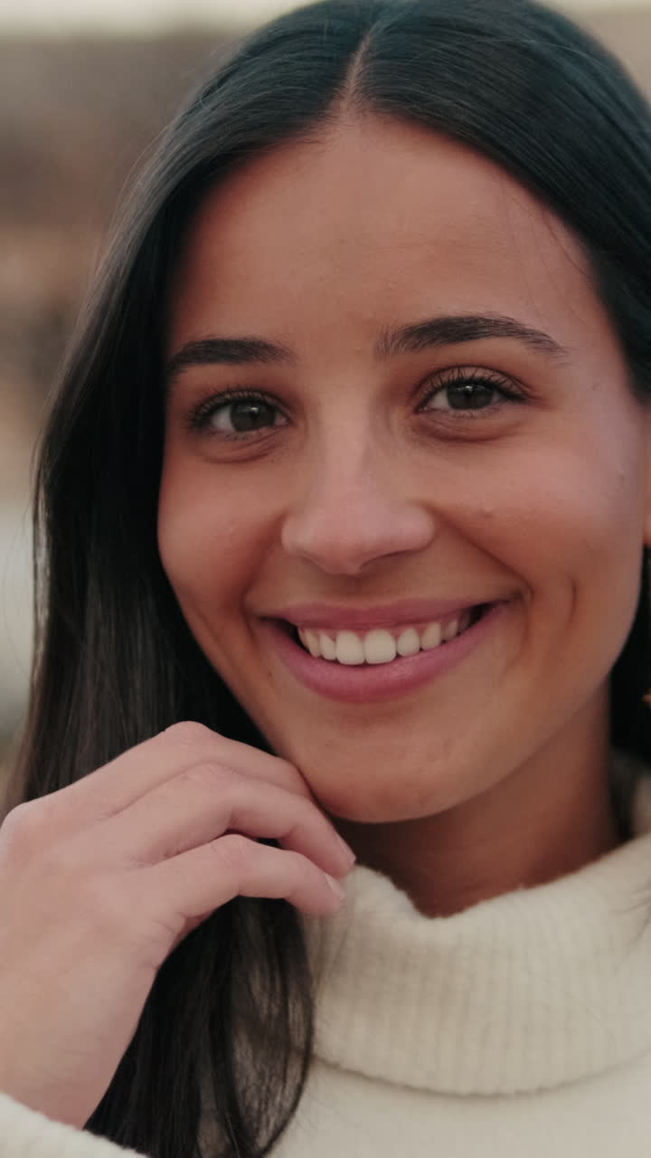 Close-up of young woman looking at camera with smile on old city background