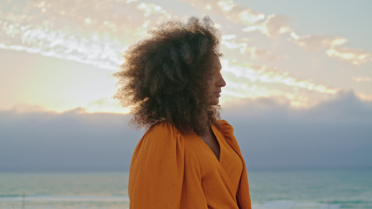 Curly woman posing cloudy summer nature in desert closeup. Portrait pretty model