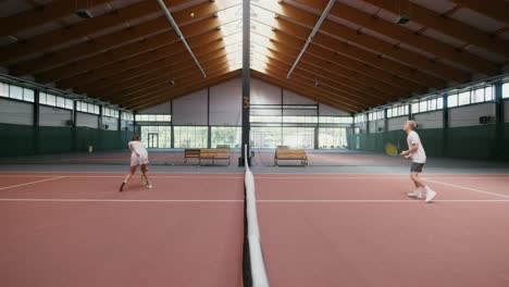 couple playing tennis indoor