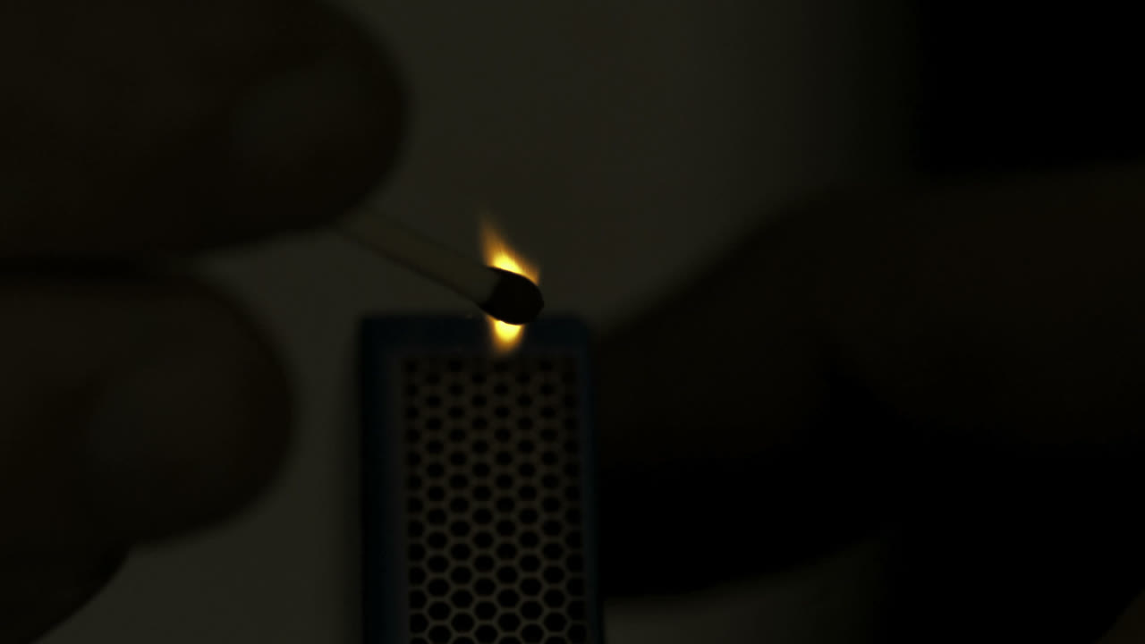 una cerilla encendida en la oscuridad en cámara lenta