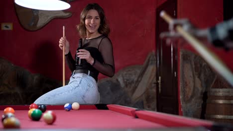 happy couple playing billiards in pub