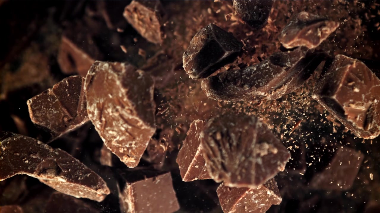 Pezzi e scaglie di cioccolato fondente che cadono al rallentatore