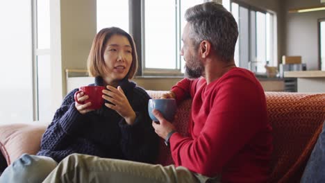 다양한 행복 한 커플 이 거실 에 앉아 커피 를 마시고 대화 하고 있다