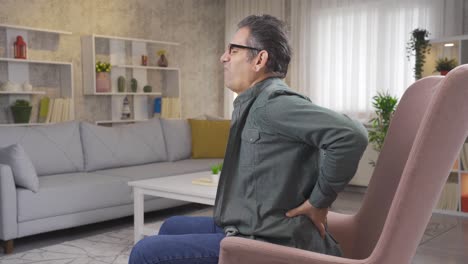 hombre maduro con hernia de disco tiene dolor en la espalda y tiene dificultad para moverse.