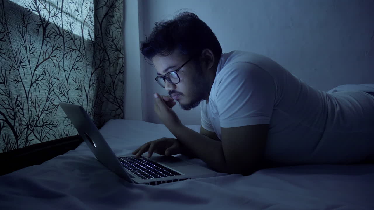 dipendente aziendale che lavora fino a tarda notte a letto indossando un abito casual