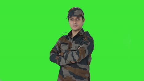 portrait of indian army man standing crossed hands green screen