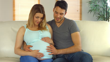 Pareja-Feliz-Sentada-En-El-Sofá