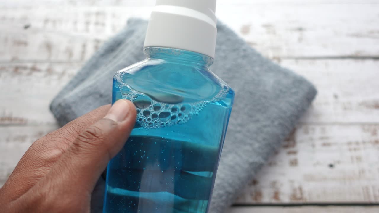 Closeup of a bottle of mouthwash being held in a hand