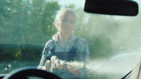 inside view of a car a woman washes her car with a high pressure washer