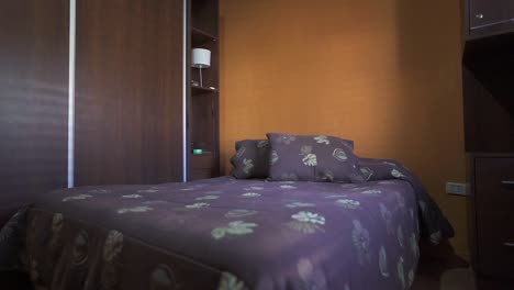 detailed forward moving scene inside house single bed room, containing purple-ish bed cover, yellow wall and wooden closet. shot on 4k.