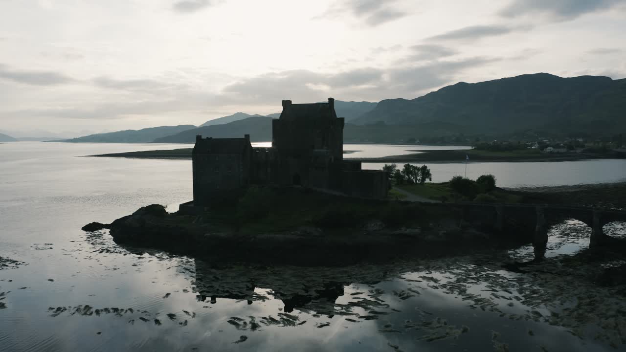silueta del castillo en el campo de escocia rodeado de agua