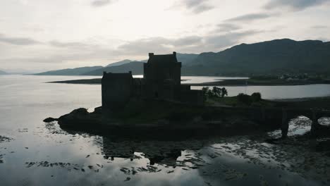 castle silhouette in scotland's countryside surrounded by water