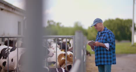 Agricultor-Gesticulando-Mientras-Escribía-En-El-Portapapeles-Contra-El-Granero-21