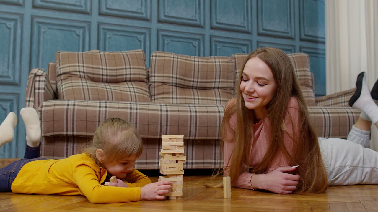 madre juega con bloques de madera juego de mesa con la hija pequeña niña niña en casa, pasatiempos de ocio