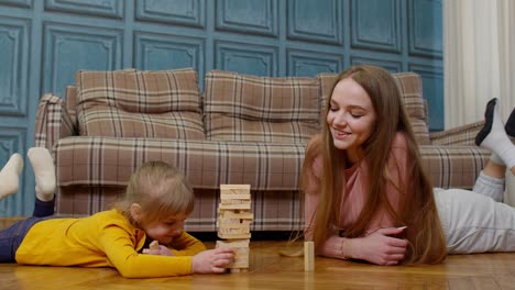 Madre-Juega-Bloques-De-Madera-Juego-De-Mesa-Con-Hija-Pequeña-Niña-En-Casa,-Pasatiempos-De-Ocio