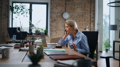confident business woman calling smartphone sitting office. manager consulting