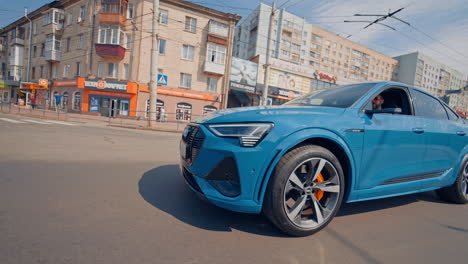 audi drives on urban road. audi e tron fully electric mid size luxury crossover suv