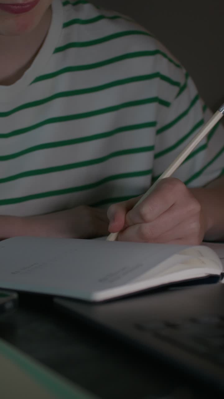 persona escribiendo en un cuaderno por la noche