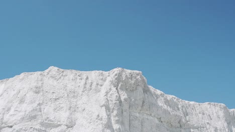 male athlete runs on a white mountain raising hands up. victory celebration