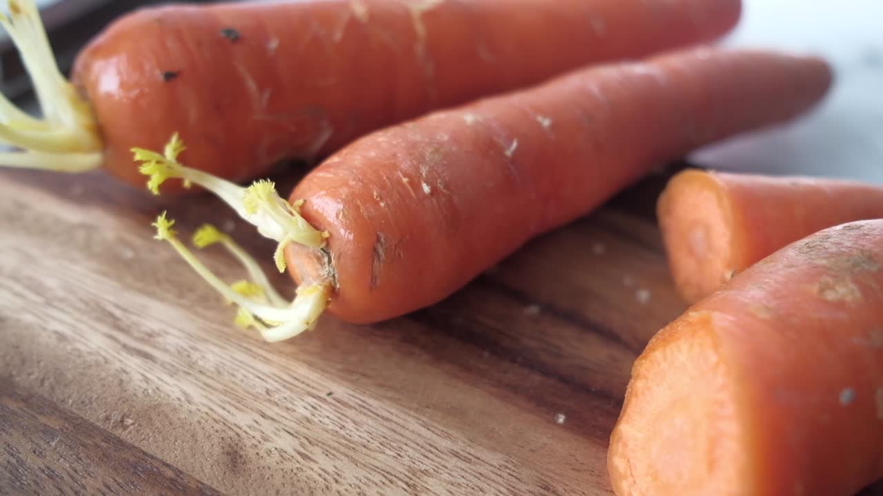 fresh carrots on chopping board on table
