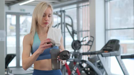 woman preparing protein shake at the gym