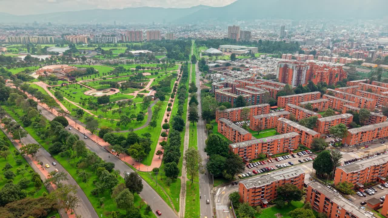 Dolly out aerial view of Virgilio Barco park and the residential buildings of Teusaquillo in the city of Bogota, Colombia, light fog.