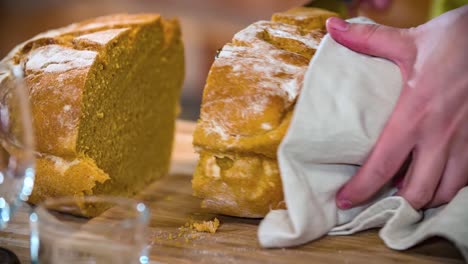 Nahaufnahme-Der-Hände-Des-Kochs,-Die-Brot-Mit-Einem-Scharfen-Messer-Halbieren-Und-Eine-Weitere-Halbe-Portion-In-Der-Hand-Halten