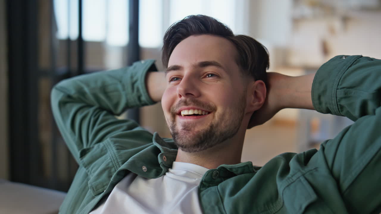 Carefree guy falling on couch feeling relaxed at home closeup. Happy student