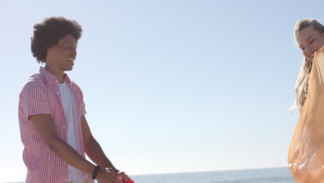 Young-African-American-man-enjoys-a-sunny-beach-day,-with-copy-space