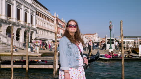 a woman traveler on the pier near ponte della paglia during summer in venice, italy