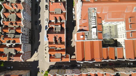 Drone-Aéreo-Volando-Sobre-Vehículos-Estacionados-En-La-Carretera-Junto-Con-Edificios-De-Techo-Rojo-Del-Casco-Antiguo-En-Un-Día-Soleado-En-Gdansk,-Polonia---Vista-De-Arriba-Hacia-Abajo