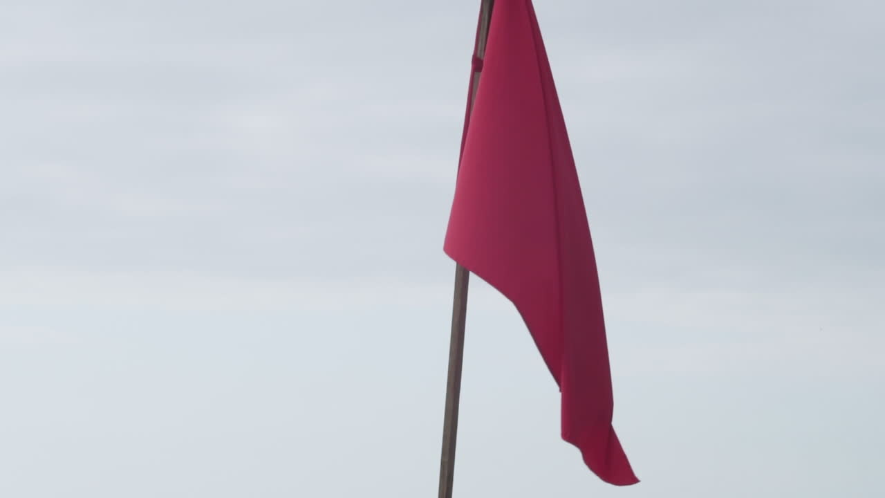 bandera de advertencia de alto peligro en el poste en la playa de olon