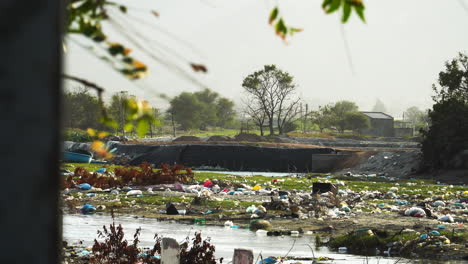 polluted river bank with plastic garbage trash in third world country